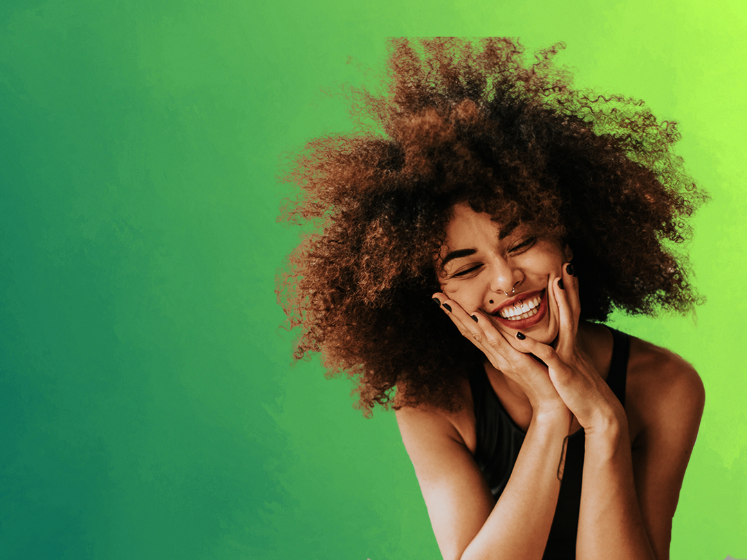 uśmiechnięta młoda kobieta na zielonym tle