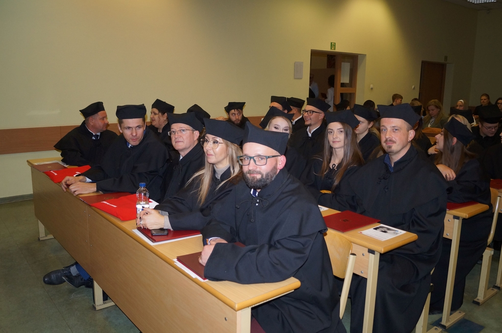 absolwenci siedzacy w ławach na auli 2