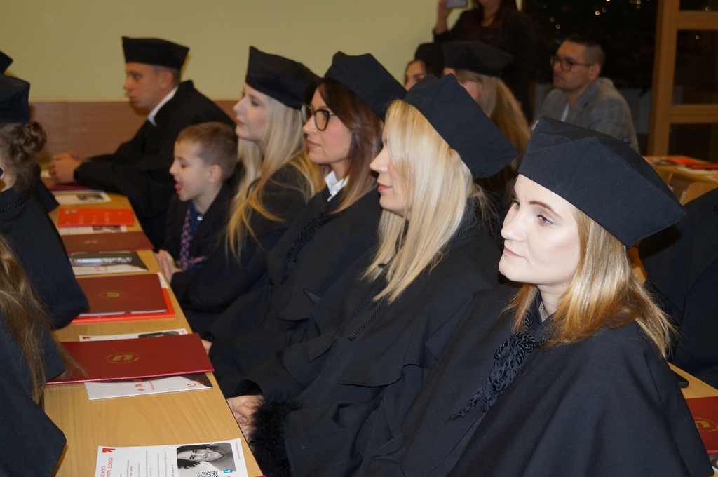 absolwenci w togach siedzacy w ławach