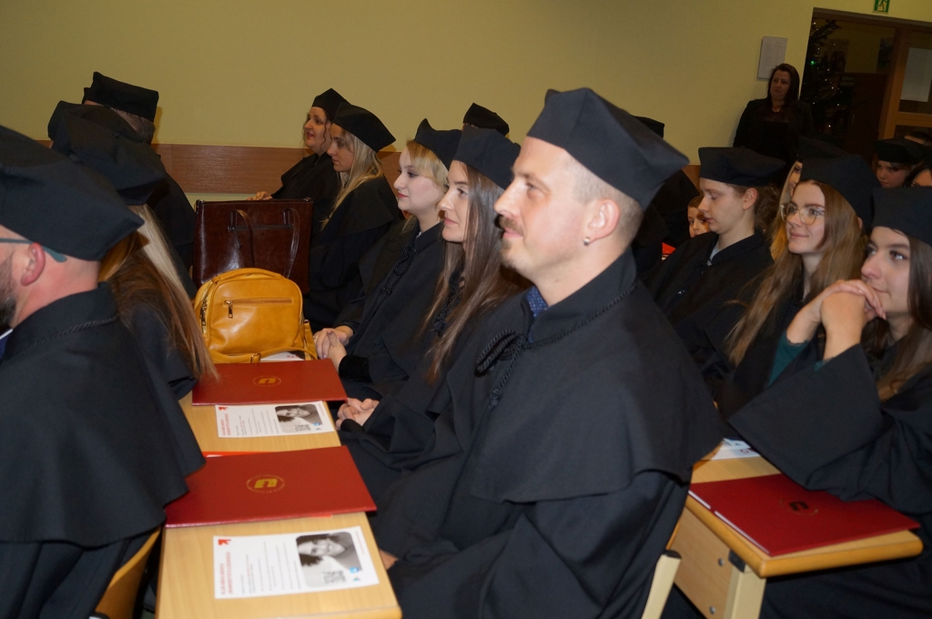 absolwenci w togach siedzacy w ławach