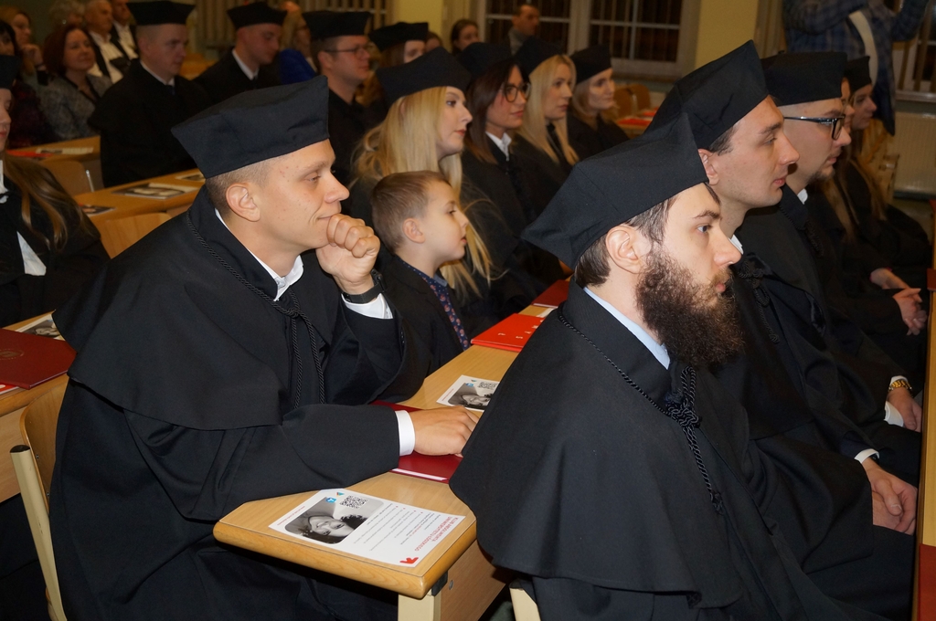 absolwenci w togach siedzacy w ławach