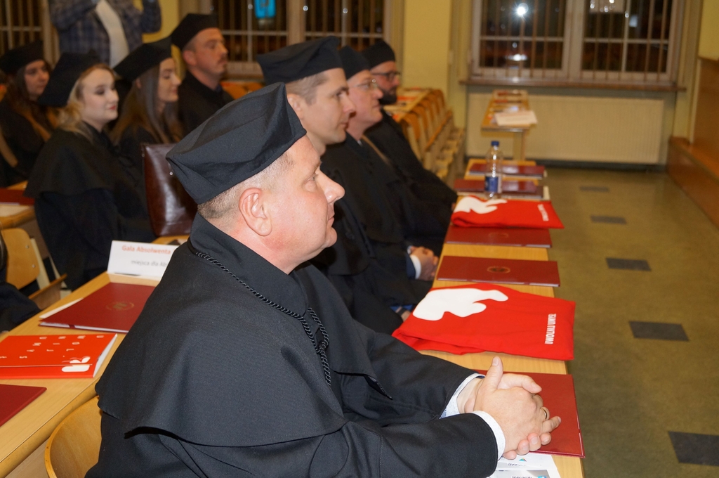 absolwenci w togach siedzacy w ławach