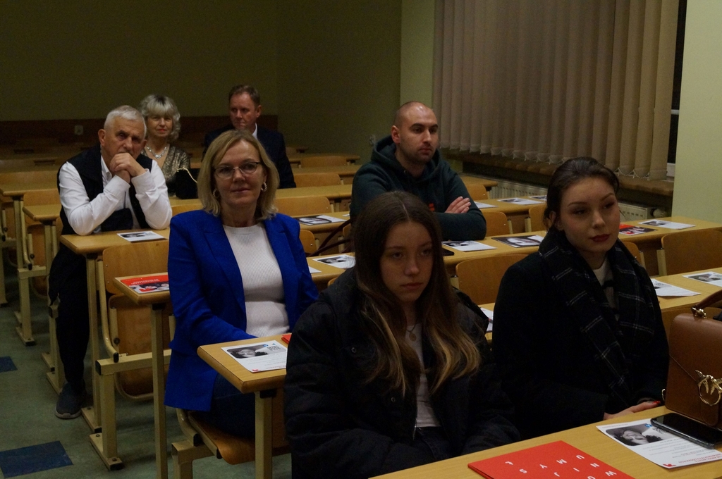 osoby siedzące w ławach w auli 