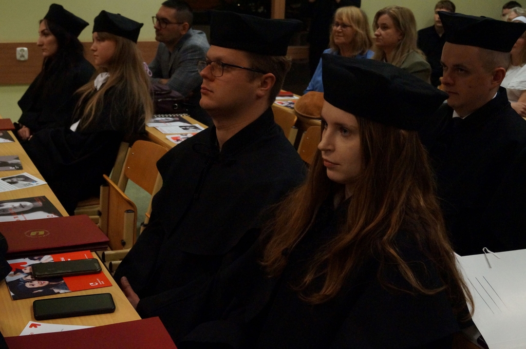 absolwenci siedzący w ławach