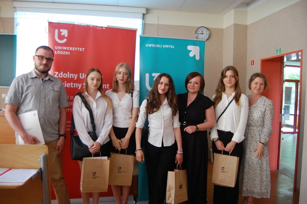 Uczestnicy seminarium podsumowującego VII edycję programu "Zdolny uczeń-świetny student" na  tle banerów Wydziału Chemii UŁ i  baneru ZUŚS