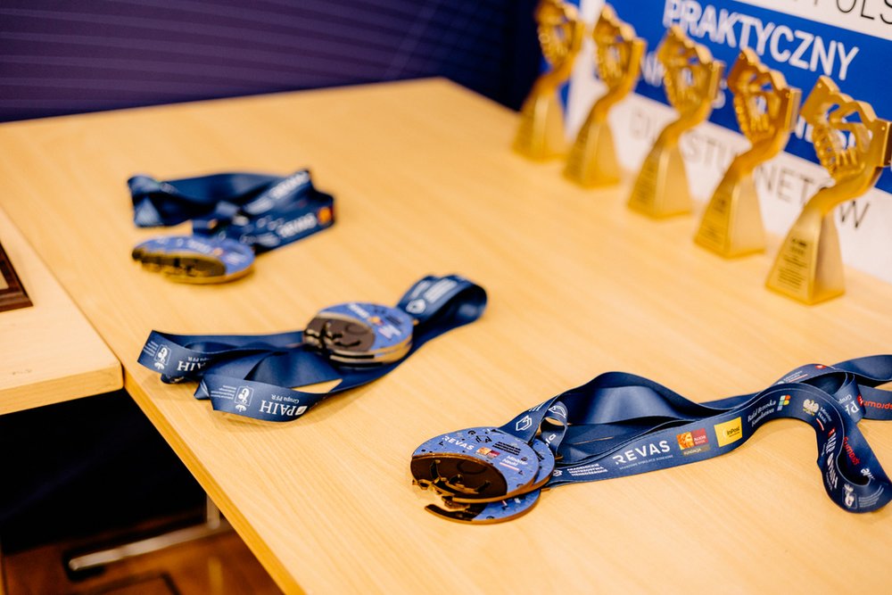 medale dla uczestników leżące na stoje w tle statuetki